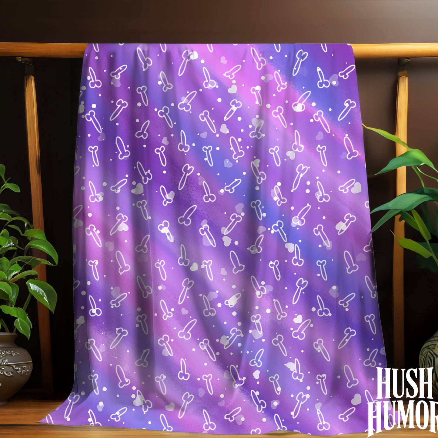 Purple towel with white patterns draped over a wooden rack, with plants on either side.
