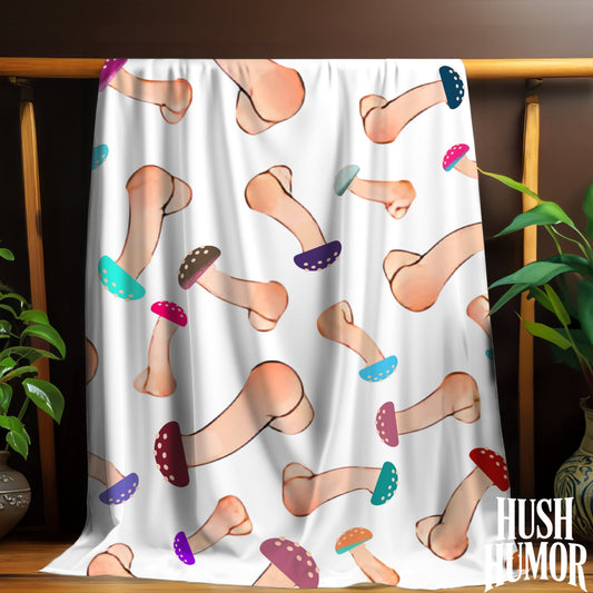 Blanket with cartoonish penis pattern draped over a wooden rack with plants on either side.